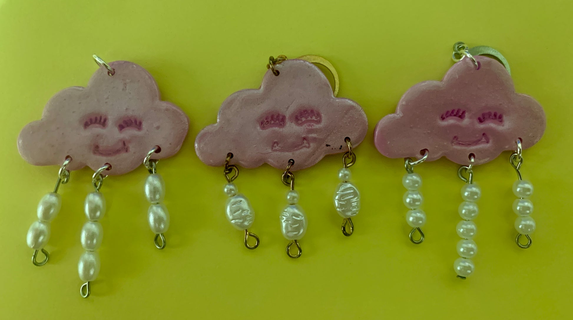 Green Happy Cloud Dangles - Studio Mintii Add some playful charm to your outfit with our Green Happy Cloud Dangles. These glittery green earrings are accented with faux pearls for a touch of elegance. Get ready to shine like a cloud on a sunny day! Note: Last image is an example of different types of bead detailing I can do. Options go from left to right as; Beads 1, 2, or 3  #