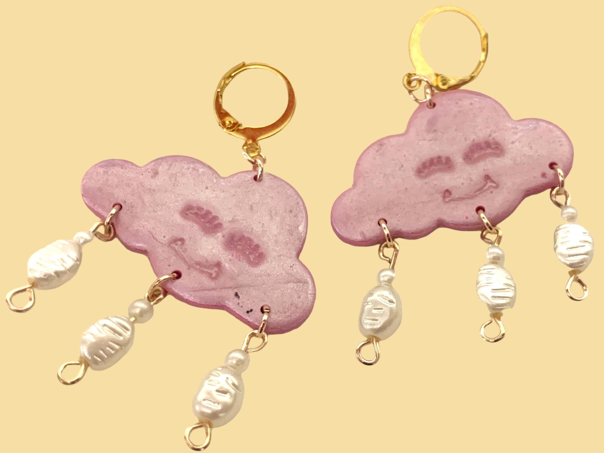 Pink Happy Cloud Dangles - Studio Mintii Channel your inner dreamer with these playful Pink Happy Cloud Dangles. These glittery pink cloud dangle earrings add a touch of whimsy to any outfit. Embrace your unique style with a touch of sparkle and charm. (Go ahead, wear them on a cloudy day!) Note: Last image is an example of different types of bead detailing I can do. Options go from left to right as; Beads 1, 2, or 3  #